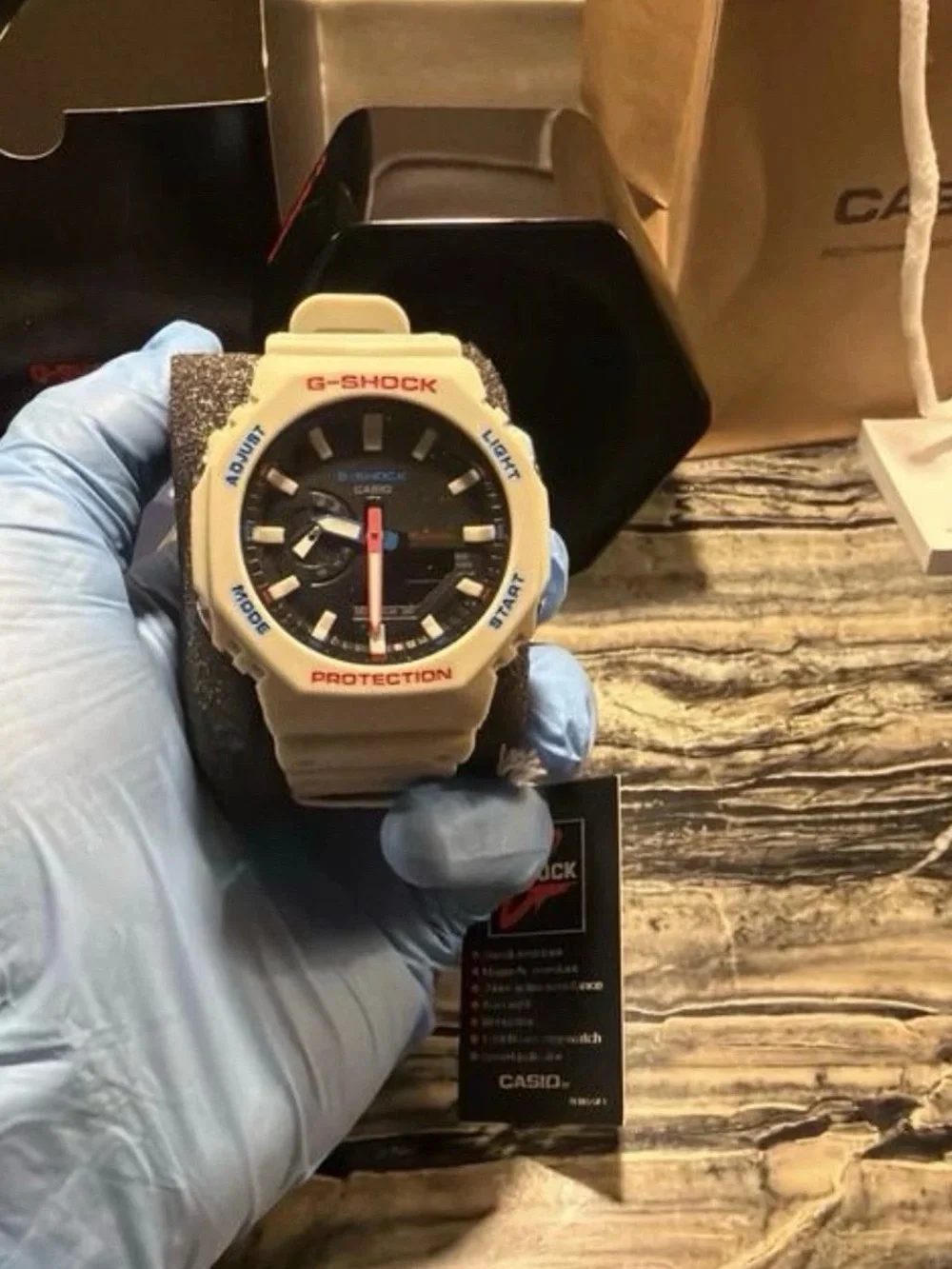 G-Shock White Bezel Black Dial Watch with Red and Blue Accents text 5045474637